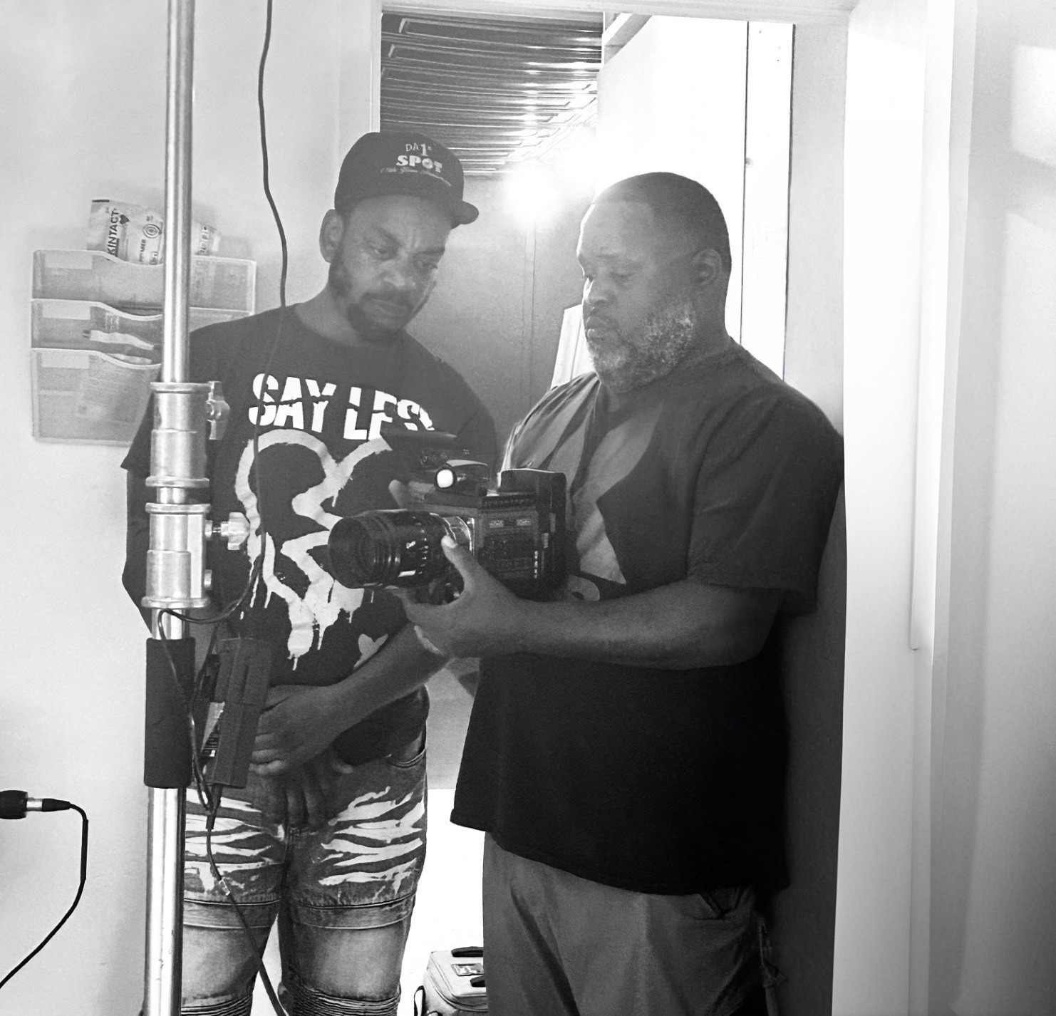 An active film set with crew members working diligently around a camera, capturing a scene. The environment should feel dynamic and focused. Use natural lighting. 4k resolution.